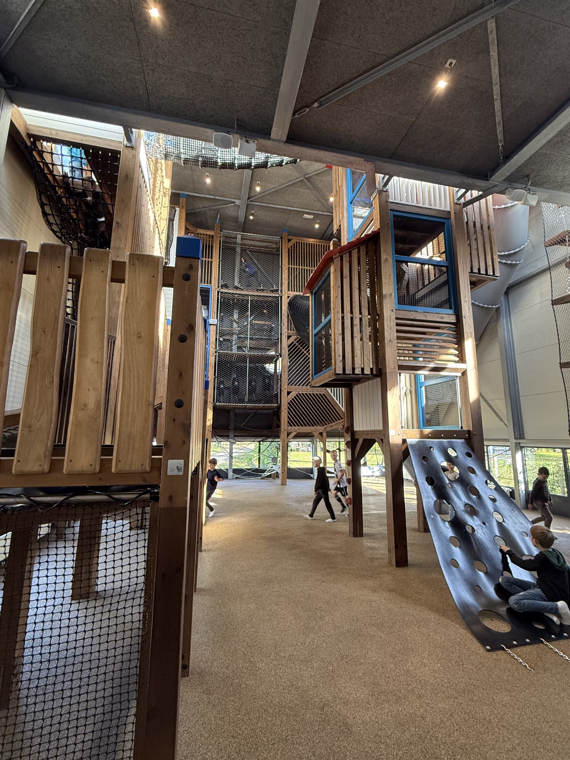 Hoge binnenspeeltuin met klimtorens en netten